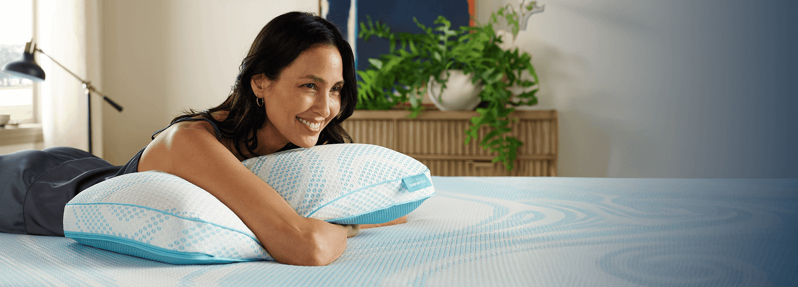 Woman hugging a Breeze pillow on a mattress