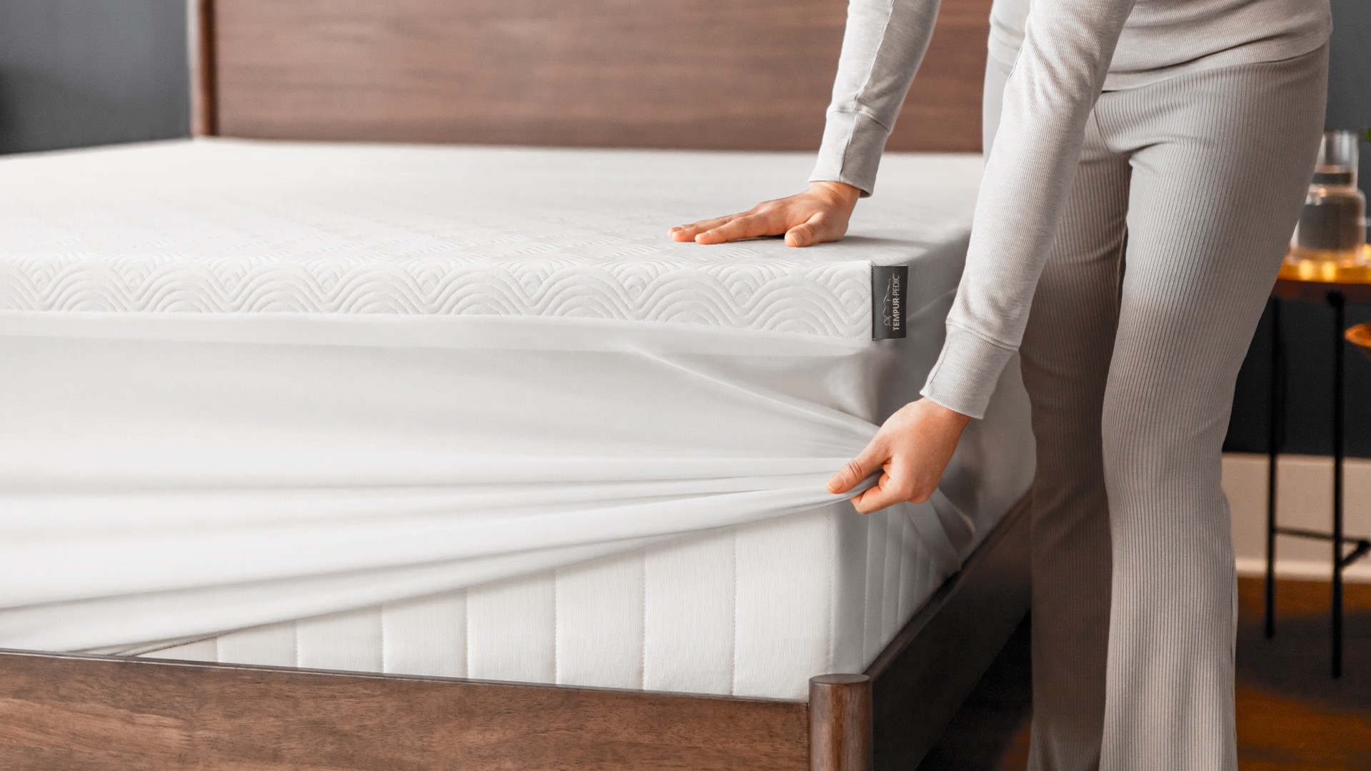 woman putting Tempur-Cloud topper onto mattess