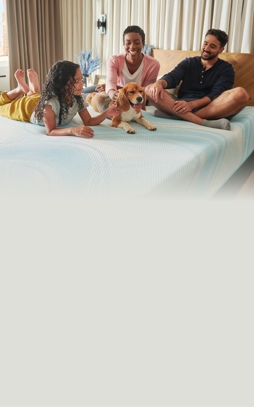 Family lounging with dog on their Tempur mattress