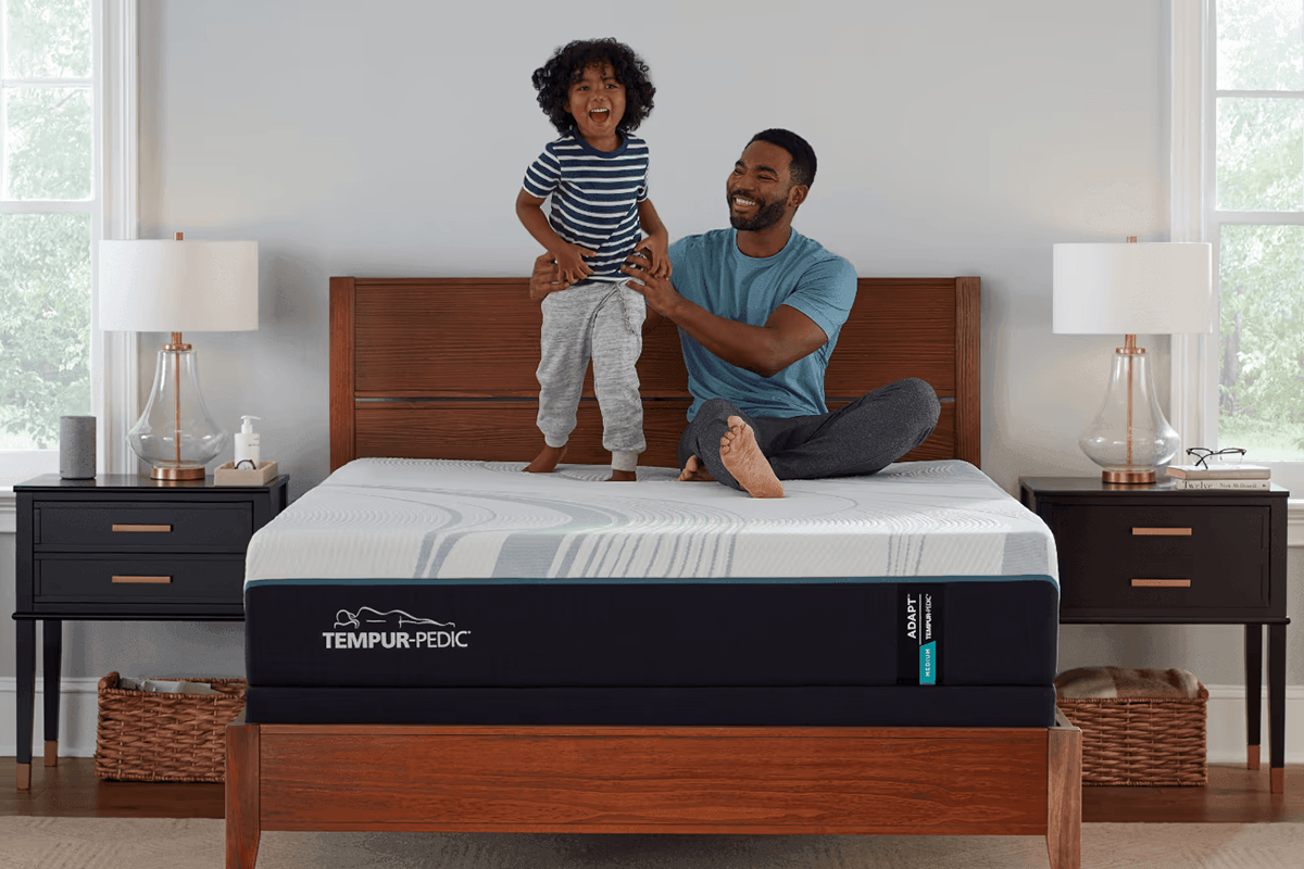 child and father jumping on the bed