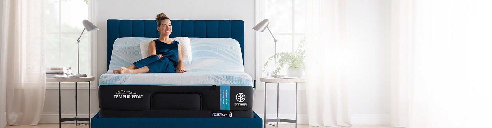 Woman sitting on Tempur breeze mattress in a styled room