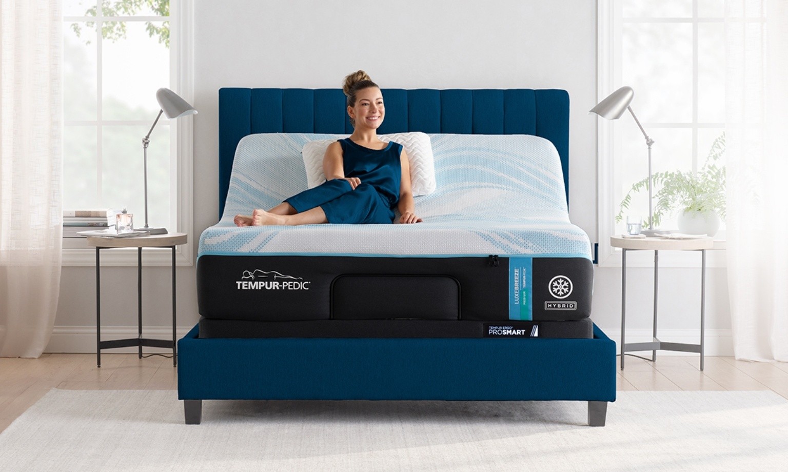 Woman sitting on Tempur breeze mattress in a styled room