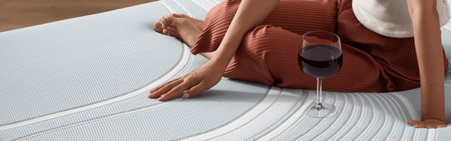 a woman with a wine glass on the adapt mattress collection