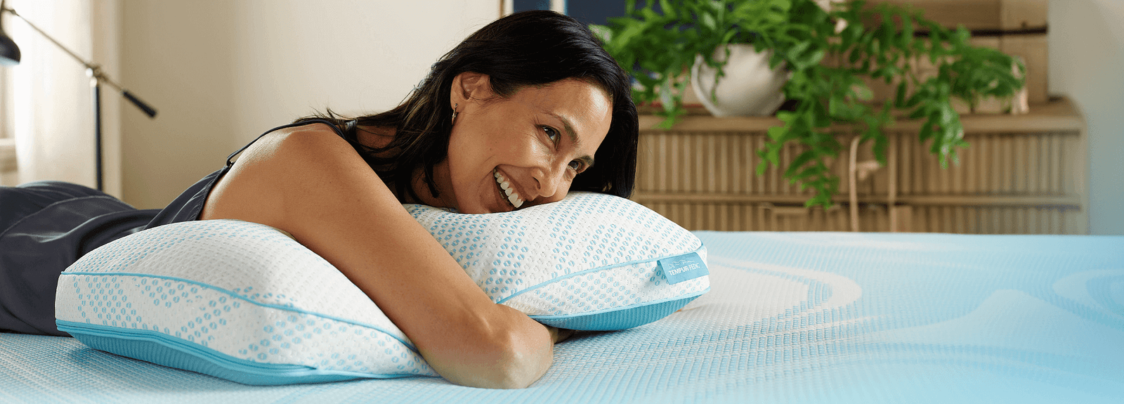 Woman hugging Breeze pillow in bed