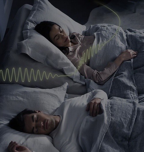 Couple sleeping in a bed with snore response